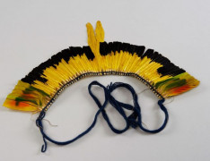 COIFFE en plumes jaunes et noires au recto et vertes au verso. Amazone aourou, cacique à dos jaune et cacique huppé. Haut. : 18 cm,...