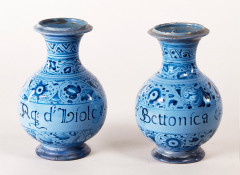 PAIRE DE BOUTEILLES à col large, décor floral bleu sur fond bleu clair,  inscriptions : "Aq d'hiole" et "Aq d'Bettonica". Haut.: 23,...