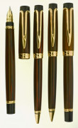 WATERMAN Parure plume + bille + mine + roller de la collection Liaison. Ebonite foncée marbrée avec les attributs plaqués or. Plum...