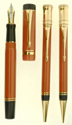 PARKER Parure plume Centenial + bille + mine de la collection Duofold. Résine orange et attributs plaqués or. Plume or 18 carats e...