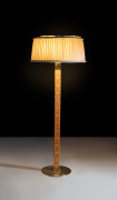 ¤ Paavo TYNELL 1890-1973 Lampadaire, mod. 9611 - Circa 1950 Base en laiton, fût en bois sculpté et laiton, abat-jour en tissu, attache.