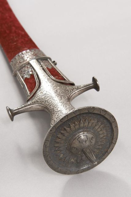 Sabre de l'Inde dit Talwar. Monture en fer ciselé argenté. Pommeau en disque surmonté d'une pointe à quatre pans. Garde à deux quill...