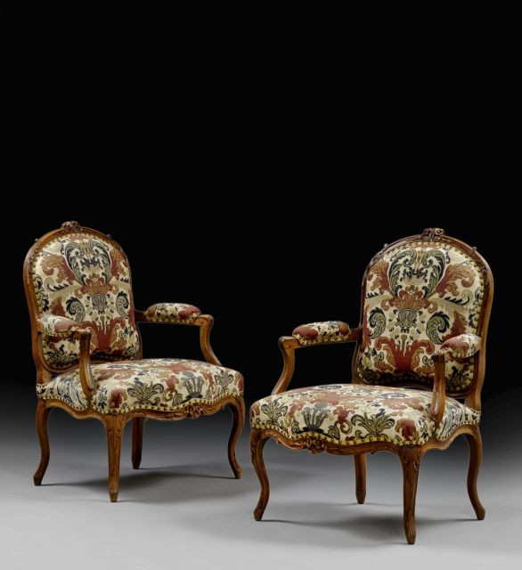 PAIRE DE FAUTEUILS A LA REINE D'EPOQUE LOUIS XV En noyer mouluré et sculpté, le dossier arrondi surmonté de fleurettes, reposant sur de