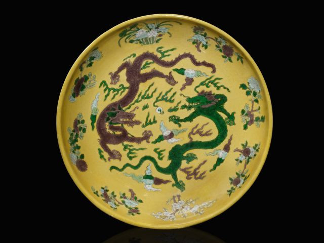 GRAND PLAT EN PORCELAINE À FOND JAUNE ET DÉCOR DE DRAGONS AUBERGINE ET VERT, CHINE, DYNASTIE QING, MARQUE ET ÉPOQUE KANGXI (1662-172...