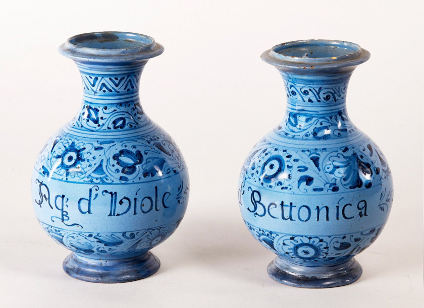 PAIRE DE BOUTEILLES à col large, décor floral bleu sur fond bleu clair,  inscriptions : "Aq d'hiole" et "Aq d'Bettonica". Haut.: 23,...