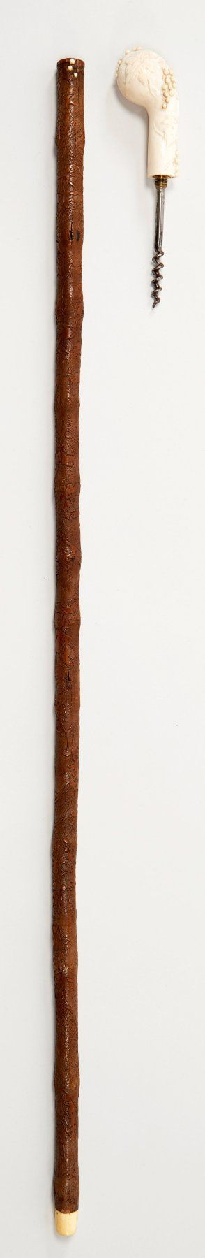 JOLIE CANNE D'OENOLOGUE, pommeau en ivoire sculpté de feuilles et de grappes de raisin, se dévissant et découvrant un tire-bouchon....