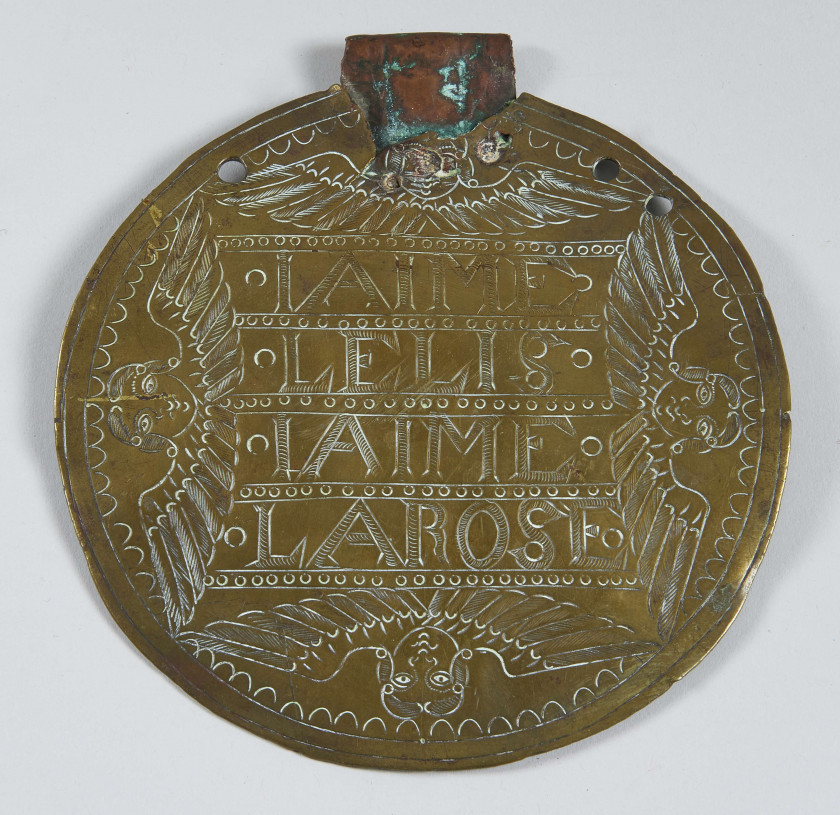 PLAQUE MULETIERE En laiton gravée de l’inscription : « IAIME LE LIS IAIME LA ROSE » (sic) et quatre têtes d’anges. Diam. : 15,5 cm...