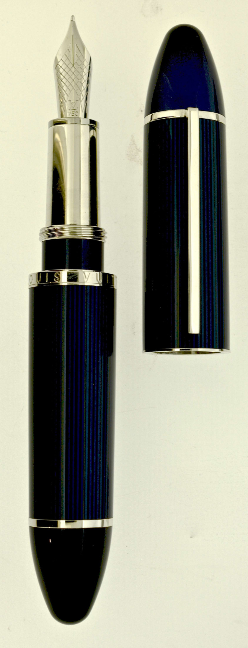 LOUIS VUITTON Stylo plume de gros gabarit. Laque bleue, striée de noir et attributs rhodiés. Plume or 18 carats moyenne, remplissa...