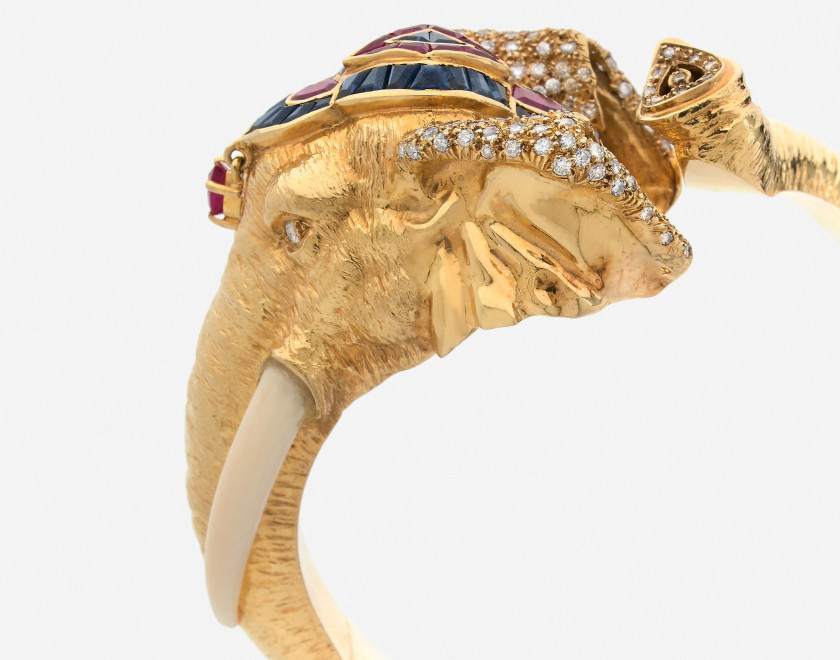 Bracelet rigide ouvrant éléphant en or, diamants, rubis et saphirs A diamond, ruby, sapphire and gold elephant bangle