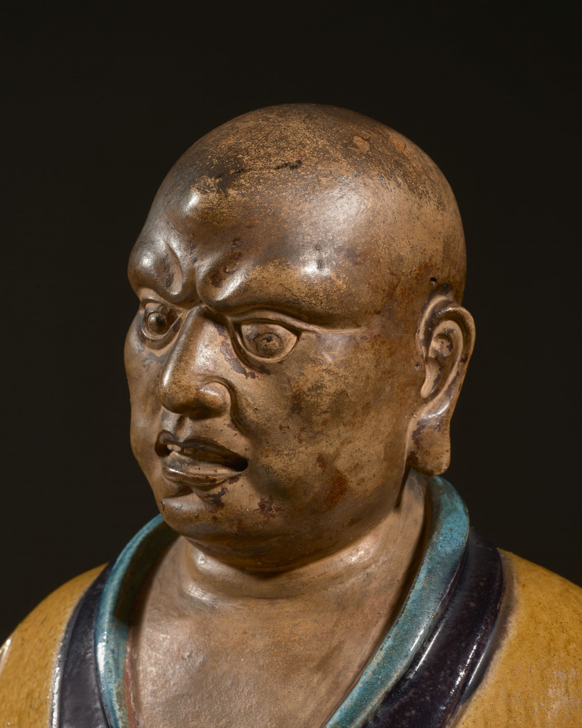 IMPORTANTE STATUE DE LUOHAN EN GRÈS ÉMAILLÉ JAUNE, TURQUOISE ET AUBERGINE, Chine, dynastie Ming (1368-1644)